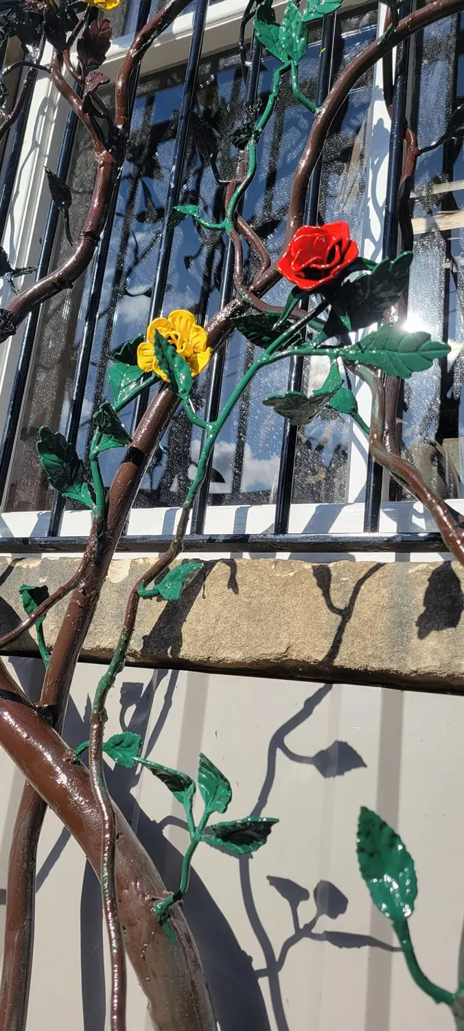 Painted rose and leaf detail on bespoke steel tree security bars