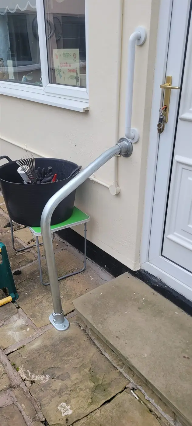 Metal handrail fitted beside outdoor steps