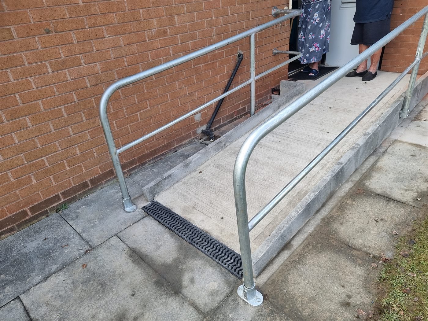 Galvanised ramp handrail fitted outside a brick home