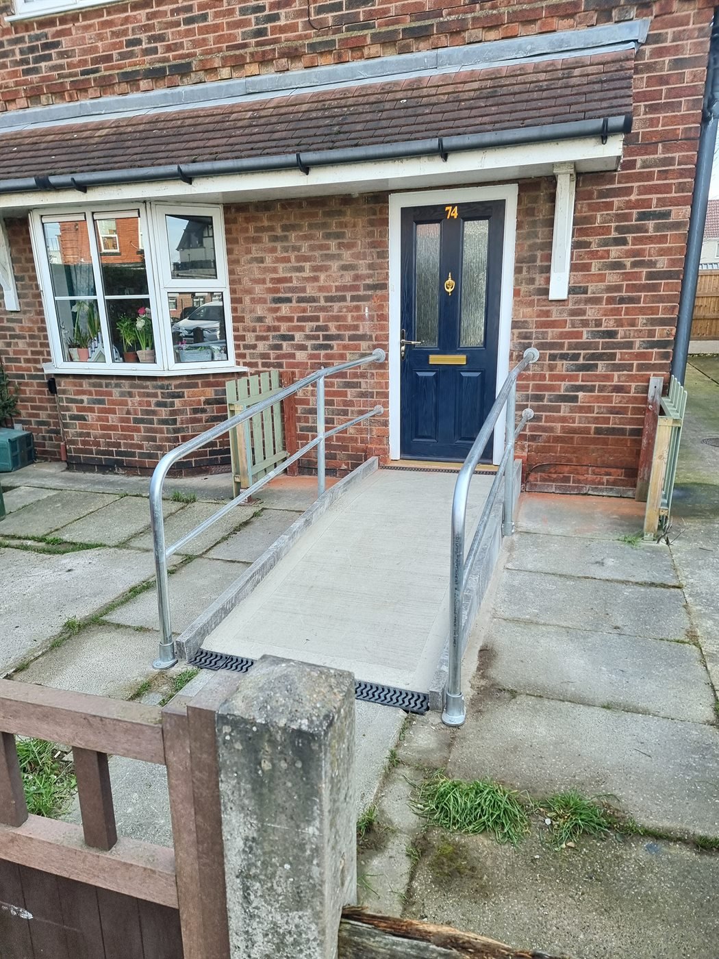 Metal handrail fitted beside a stepped entrance
