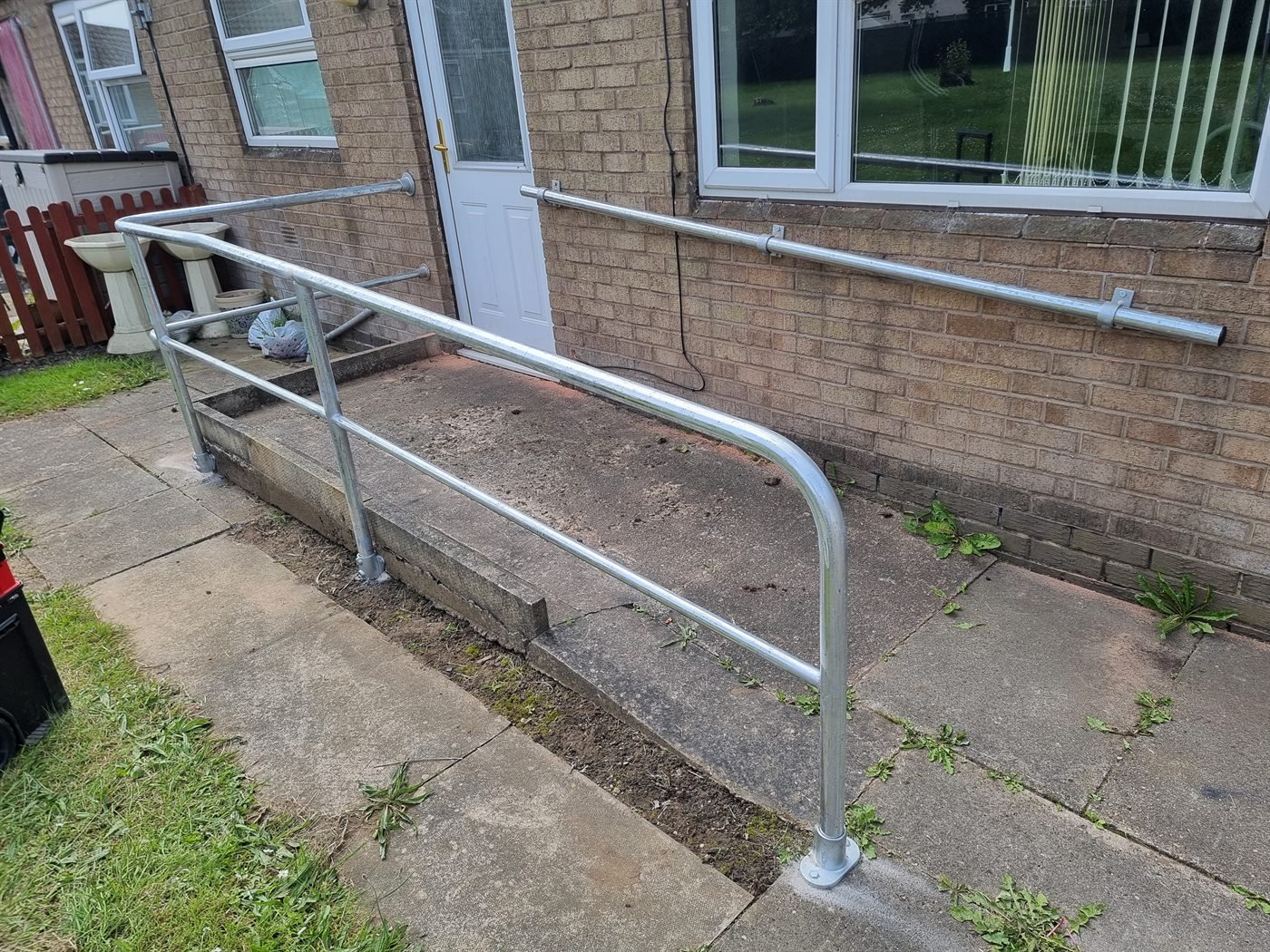 Metal handrail fitted along a front path and steps