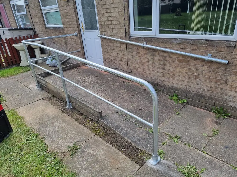 Metal handrail fitted along a front path and steps