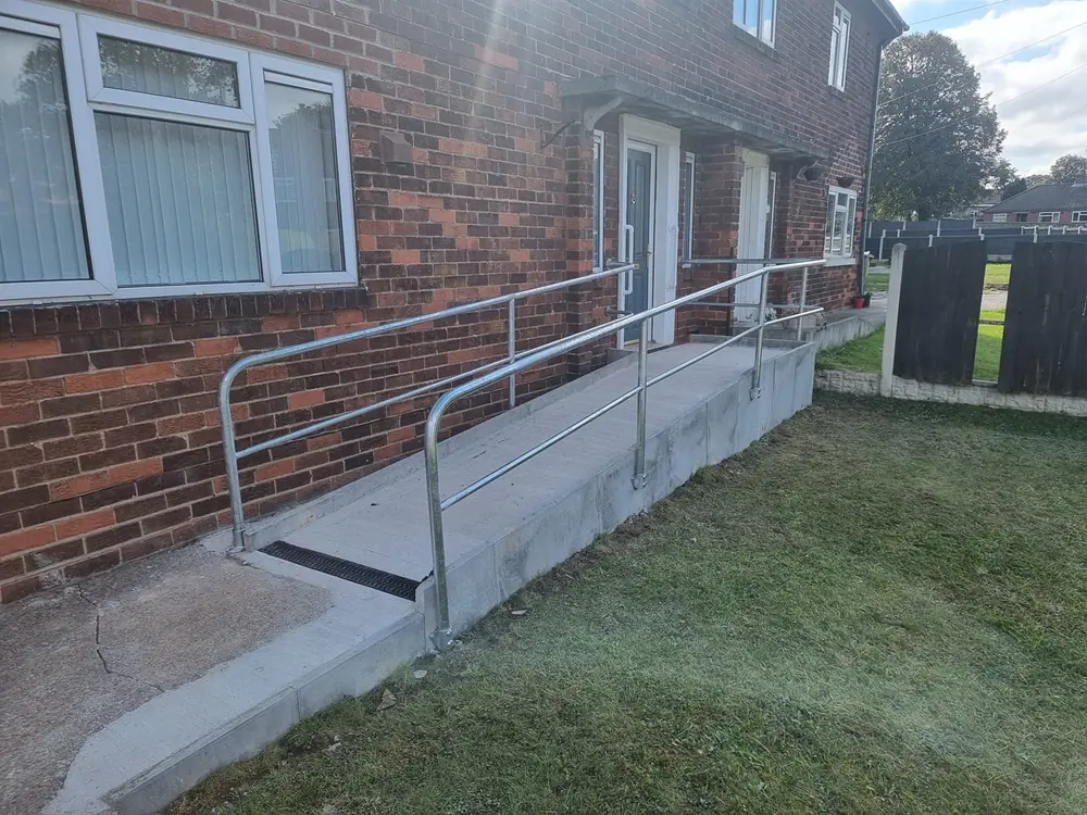 Long galvanised metal handrail fitted along an access ramp