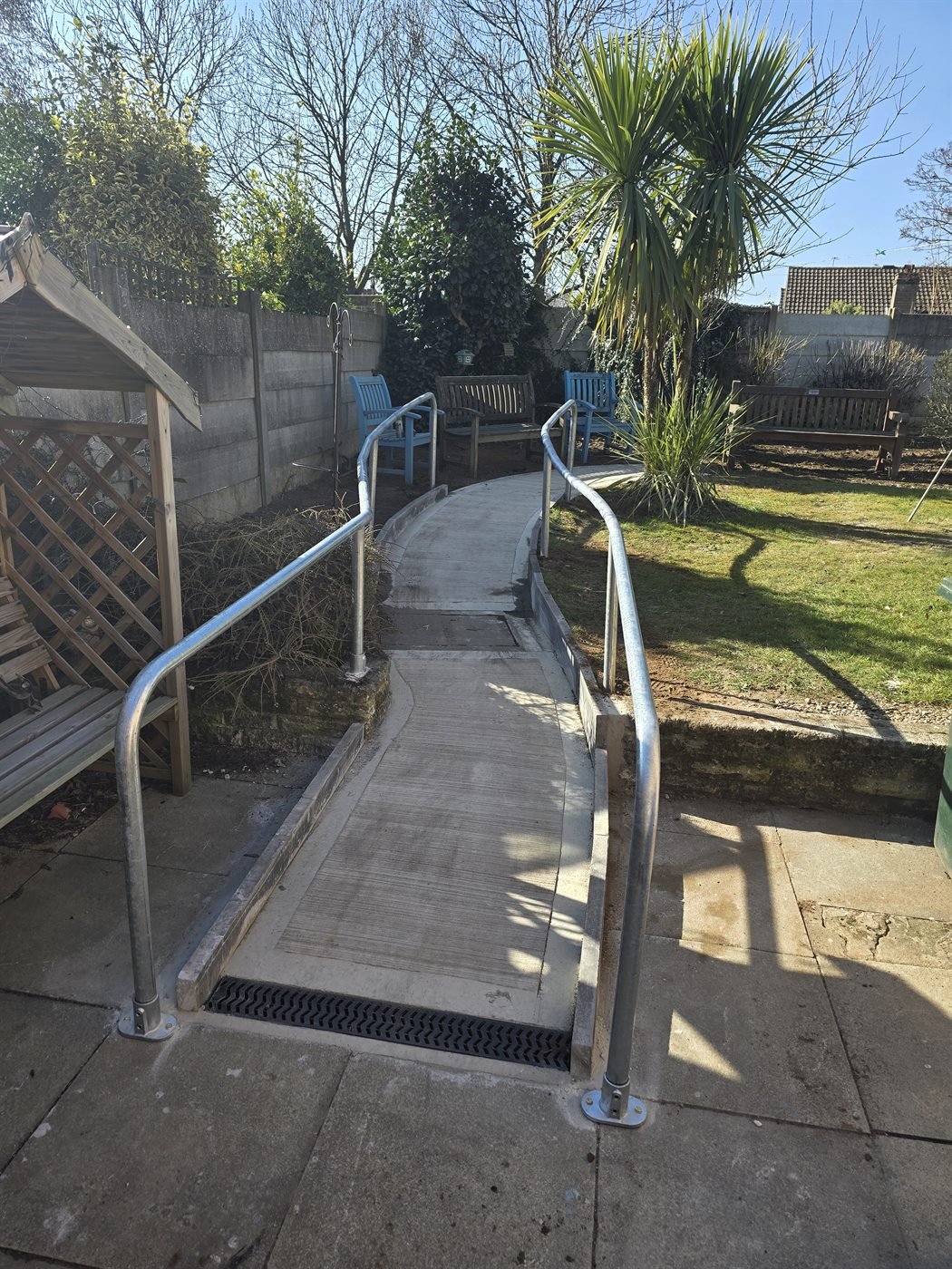 Galvanised ramp handrail fitted beside a garden wall